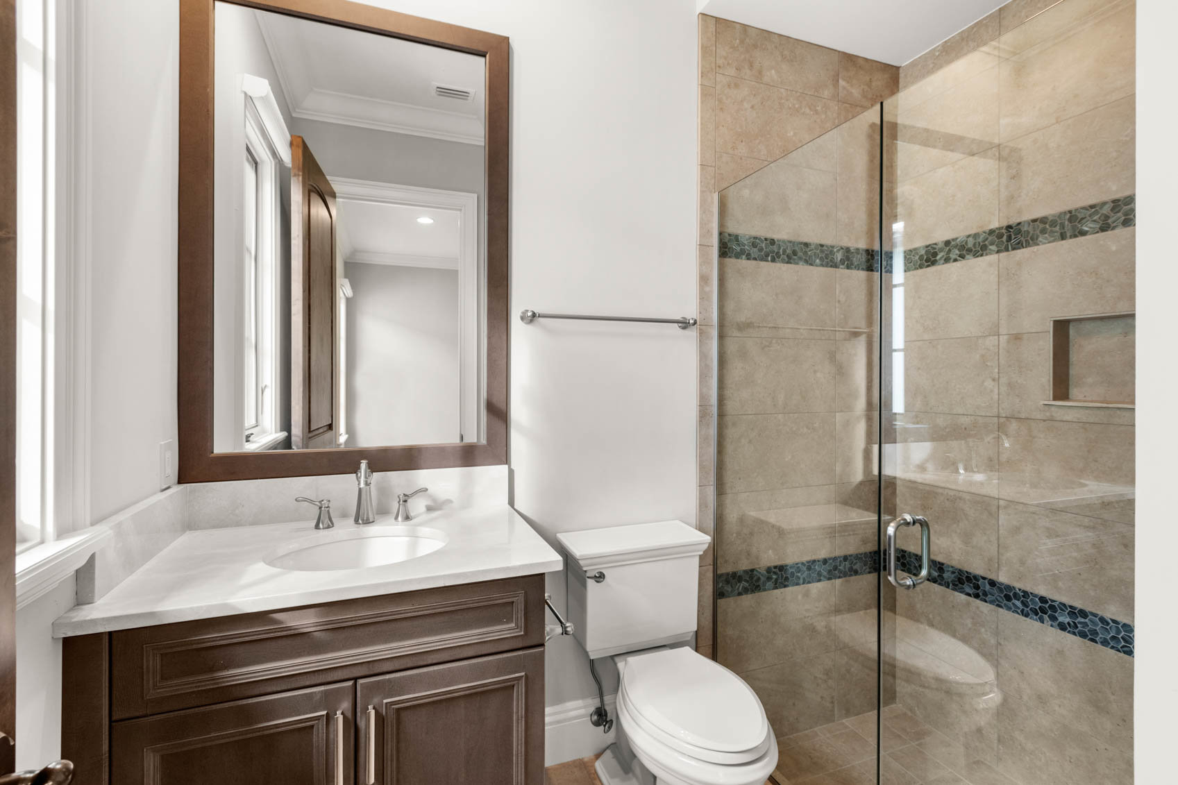 bathroom with white counter and tiled shower